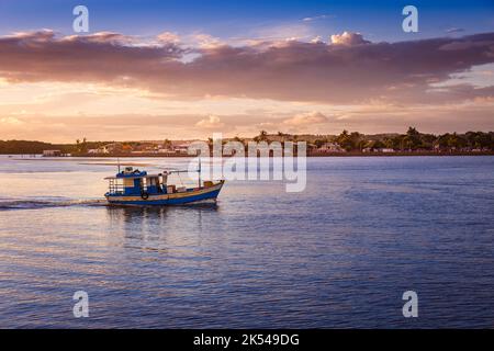 Idyllischer Strand bei Sonnenuntergang mit Palmen und Trawlerboot in Porto Seguro, BAHIA Stockfoto