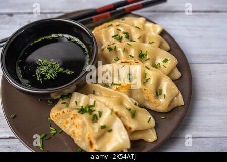 Hausgemachte, frittierte asiatische Potsticker-Vorspeise. Gyzo Asiatische Schweinepudding mit Sojasauce. Knödel auf einem Teller. Stockfoto