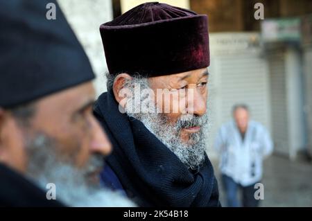 Äthiopisch-orthodoxe Priester sitzen am Damaskus-Tor in der Altstadt von Jerusalem. Stockfoto