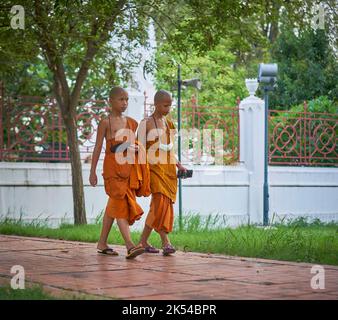 Junge Novizenmönche gehen und plaudern, aufgenommen in Ayutthaya, Thailand, im Mai 2022. Stockfoto