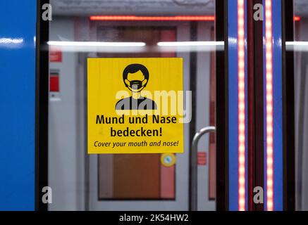 München, Deutschland. 06. Oktober 2022. Ein Aufkleber mit der Aufschrift „Cover Your Mouth and Nose“ ist an der Tür einer U-Bahn zu sehen. Quelle: Sven Hoppe/dpa/Alamy Live News Stockfoto