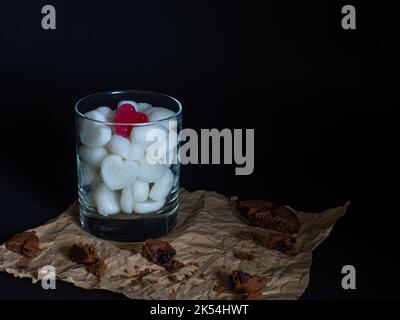 Eiswürfel aus herzförmiger Milch in Glas Stockfoto