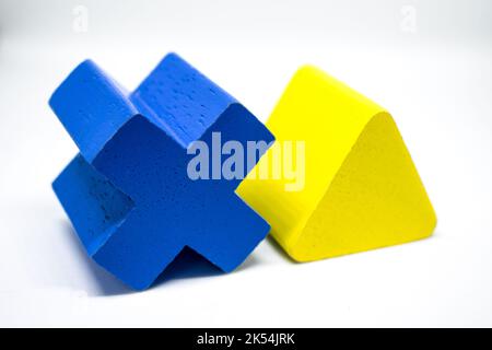 Kreuz- und Triagle-Geometrie aus Holz auf weißem Hintergrund. Stockfoto