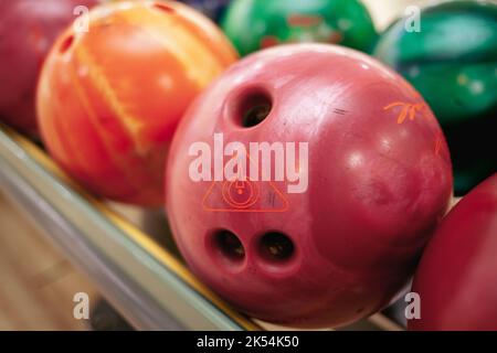 Bowling-Kugeln aus nächster Nähe. Wege mit Bällen und Pins zum Bowling. Ein lustiges Spiel für das Unternehmen. Stockfoto