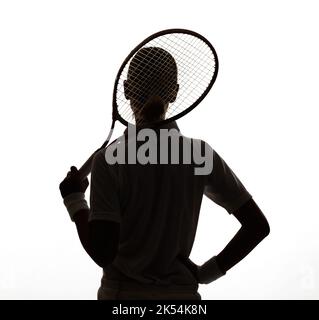 Shes das dunkle Pferd in diesem Tennis-Wettbewerb. Rückansicht der Silhouette einer jungen Frau, die ihren Tennisschläger hält. Stockfoto