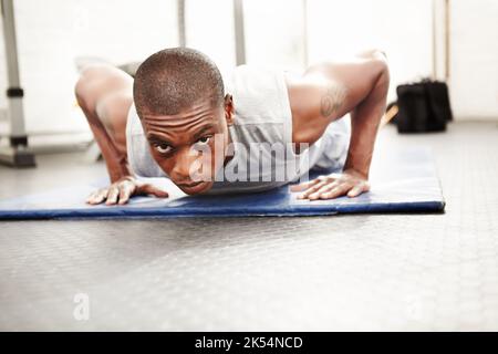 Es ist den Schmerz wert. Low-Angle-Ansicht eines Mannes, der während Liegestützen auf die Kamera schaut. Stockfoto
