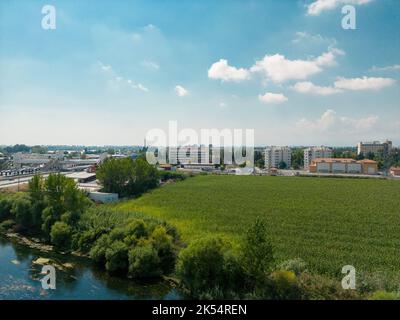 Luftbild des Gemüsefeldes am Straßenrand, das in die Stadt führt Stockfoto
