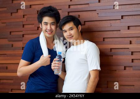 Sie arbeiten gerne zusammen. Niedlich junge Gay asiatische Paar lächelt zusammen nach dem Fitnessstudio. Stockfoto