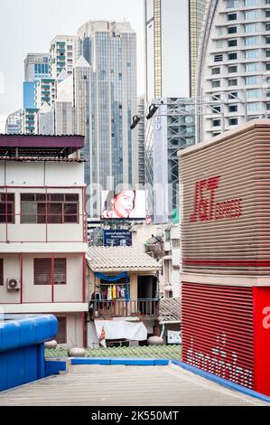 Die Aussicht über der Sukhumvit Rd An der Asoke Junction, Bangkok, Thailand, mit Blick auf die Skyline und einer hellen Neonwerbung zwischen den Wohnungen. Stockfoto