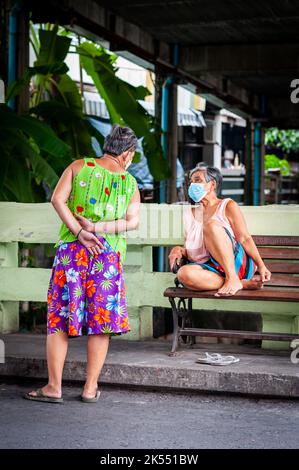 Zwei thailändische Damen unterhalten sich in den engen Straßen und Gassen des Ruamrudee-Viertels in der Nähe des Lumpini Park Bangkok Thailand. Stockfoto