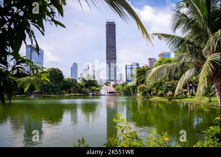 Blick auf die Straße, die Wege und den großen See im Lumphini Park, Bangkok, Thailand. Stockfoto