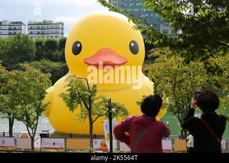 Seoul, Südkorea. 6. Oktober 2022. Am Seokchon-See in Seoul, Südkorea, beobachten und fotografieren die Menschen die Gummiente, die vom niederländischen Künstler Florentijn Hofman entworfen wurde, am 6. Oktober 2022. Quelle: Wang Yiliang/Xinhua/Alamy Live News Stockfoto