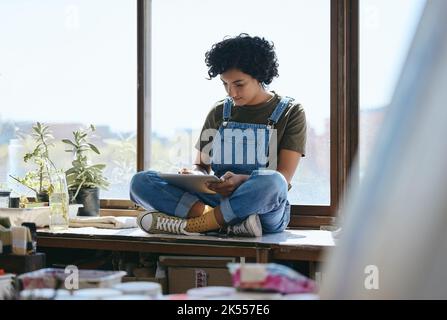 Tablet, Kunstidee und Maler im Internet zur kreativen Inspiration für die Gestaltung der Malerei in einem Atelier. Schwarze Frau, Designerin und Künstlerin im Web Stockfoto
