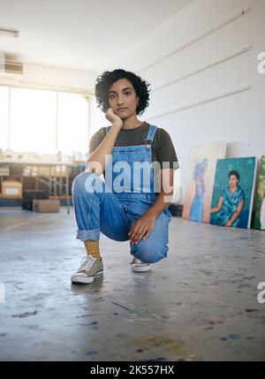Künstlerportrait im Studio, Workshop mit Galerie von Leinwandkunstwerken und junge selbstbewusste indische Frau. Professioneller kreativer Grafikmaler, coole Kunst Stockfoto