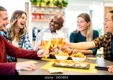 Junge Leute Freunde trinken und toasten Bier in der Brauerei Bar Restaurant - Essen Lifestyle-Konzept mit Männern und Frauen Spaß zusammen in ho Stockfoto