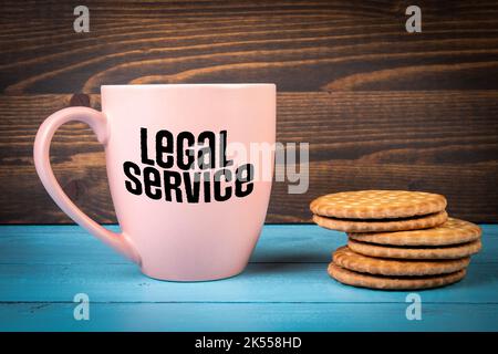 Rechtsdienst. Text auf einem Kaffeebecher. Blauer und brauner Holzhintergrund. Stockfoto