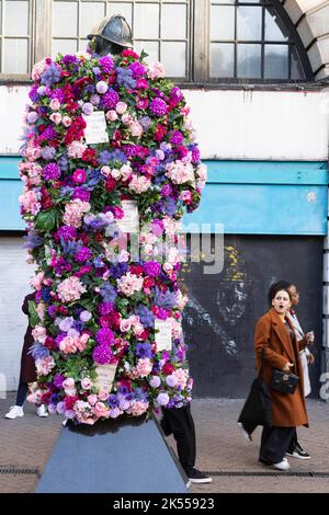 REDAKTIONELLE VERWENDUNG NUR die Sherlock Holmes Statue wird von Netflix mit einer Blumenverjüngungskur ausgestattet, um die Veröffentlichung ihrer neuesten Fortsetzung 'Enola Holmes 2' vor dem Bahnhof Baker Street in London zu feiern. Bilddatum: Donnerstag, 6. Oktober 2022. Stockfoto