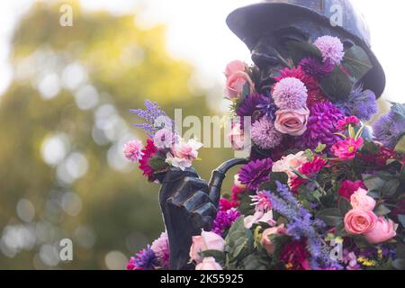 REDAKTIONELLE VERWENDUNG NUR die Sherlock Holmes Statue wird von Netflix mit einer Blumenverjüngungskur ausgestattet, um die Veröffentlichung ihrer neuesten Fortsetzung 'Enola Holmes 2' vor dem Bahnhof Baker Street in London zu feiern. Bilddatum: Donnerstag, 6. Oktober 2022. Stockfoto