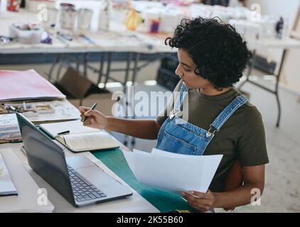 Laptop, Kunst und Dokumente mit einer Frau, die im Studio, in der Werkstatt oder im Ausstellungsraum schreibt, während sie an der Museumsleitung arbeitet. Manager, kreativ oder Papierkram mit Stockfoto