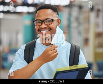 Covid, Maske und Freiheit mit schwarzem Mann oder Student an der Hochschule oder Universität mit Akte. Sicherheit, Gesundheit und Compliance für Corona-Virus-Regeln oder Stockfoto