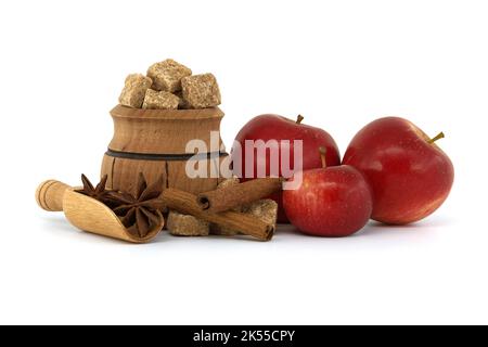 Rote Äpfel in der Nähe von Zucker, Zimtstangen und Anissterne in Holzlöffel gelegt. Backen Apfelkuchen Konzept isoliert auf weiß Stockfoto