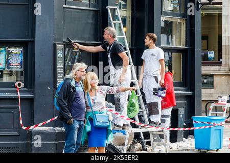 Arbeiter, die das Äußere eines Gebäudes (The World's End Pub) in Camden Town, London, Großbritannien, lackieren Stockfoto