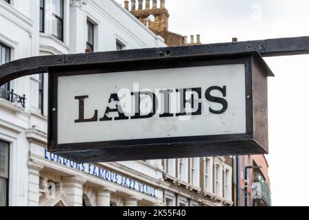 Beleuchtetes „Ladies“-Schild über dem öffentlichen Komfort der Frauen oder der Toilette in Camden Town, London, Großbritannien Stockfoto