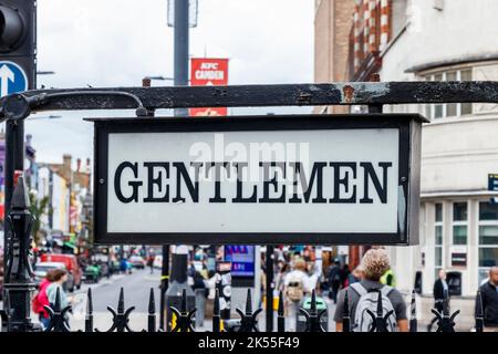 Beleuchtetes „Gentlemen“-Schild über der öffentlichen Bequemlichkeit der Herren, oder Toilette, jetzt nicht mehr benutzt, in Camden Town, London, VEREINIGTES KÖNIGREICH Stockfoto