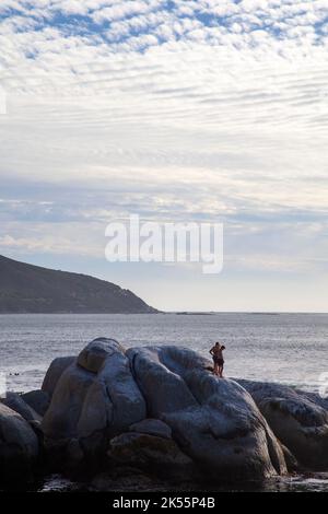 Zwei Männer auf Rocks am Bakoven Beach in Kapstadt, Südafrika Stockfoto