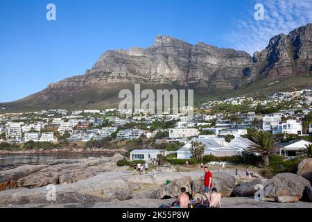 Am Bakoven Beach treffen sich Menschen zum Sonnenuntergang in Kapstadt, Südafrika Stockfoto