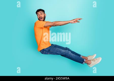 Ganzkörper-Porträt von schockierten jungen Mann fallen aussehen leeren Raum isoliert auf blauem Hintergrund Stockfoto
