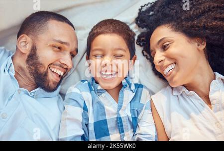 Eltern, Kind und Lächeln im Bett für glückliche Nahaufnahme zusammen zu entspannen zusammen in der Familie zu Hause. Mutter, Vater und Kind lachen komisch, lustig oder dumm Stockfoto