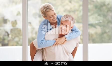Glückliches Seniorenpaar im Wohnzimmer, liebe Unterstützung im Ruhestand und lachendes Glück in der Ehe. Australien Heim mit einem lustigen älteren Mann, umarmt älter Stockfoto