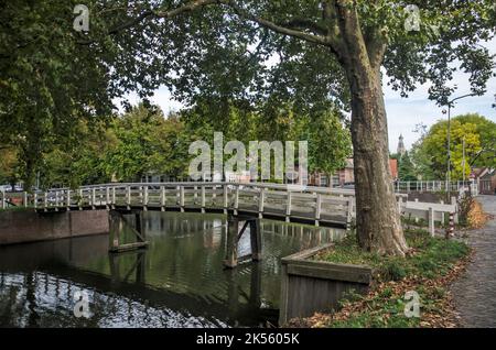 Enkhuizen, Niederlande, 4. Oktober 2022: Hölzerne Fußgängerbrücke über einen Kanal im Stadtteil Boerenhoek Stockfoto