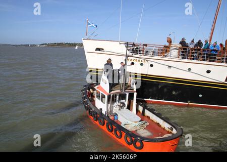 Harwich, Großbritannien. 06. Okt 2022. Der letzte noch verbliebene Raddampfer, Waverley, fährt im Rahmen der Themse-Saison zum 75.-jährigen Jubiläum zum letzten Mal am Ha'Penny Pier in Harwich ab. Die Waverley nimmt Passagiere mit auf Reisen rund um die Themse, bevor sie nach Schottland aufbrechen. Das Schlepper Fury hilft Waverley vom Pier weg. Kredit: Eastern Views/Alamy Live Nachrichten Stockfoto