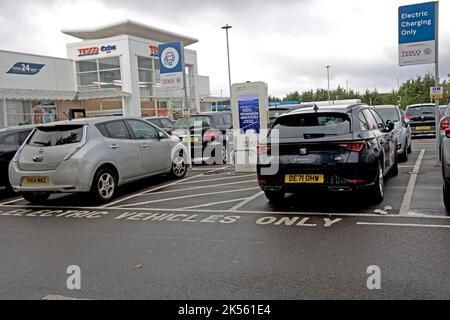 Zwei Elektrofahrzeuge laden an Tesco-freien Ladestationen mit 100 % erneuerbarem Strom bei Quedgely Gloucester UK Stockfoto