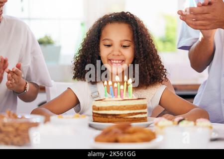 Kleines Mädchen, Geburtstag und Kerzenkuchen für den Wunsch in der Party-Feier für das Kind im Glück zu Hause. Glückliches Kind mit Lächeln sitzt bei Kerzen für die Veranstaltung Stockfoto