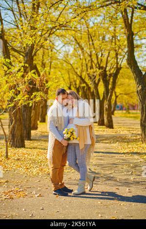 Schwanger Frau und Mann im sonnigen warmen Herbstpark Stockfoto