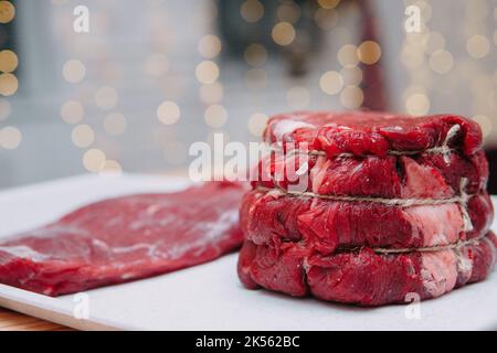 Ein Stück gealtertes Rindfleisch auf einem Teller. Nahaufnahme, selektiver Fokus. Fleisch für Steaks in einem Kochkurs. Stockfoto