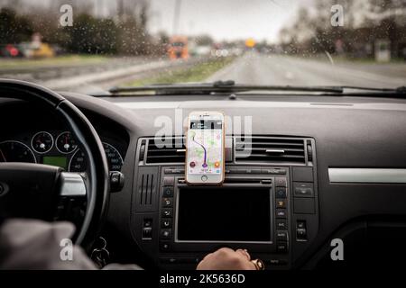 Bild einer Fahrzeugsteuerung mit einem Smartphone, das für die GPS-Navigation mit Waze in Bordeaux, Frankreich, verwendet wird. Waze, ehemals FreeMap Israel, ist ein s Stockfoto