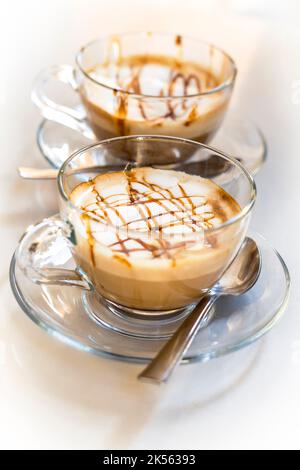 Verführerischer Karamell-Latte-Kaffee auf weißem Hintergrund Stockfoto