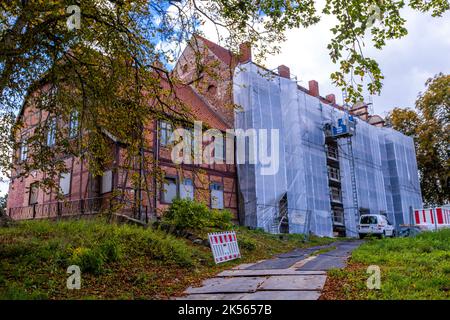 06. Oktober 2022, Mecklenburg-Vorpommern, Gadebusch: An einem Flügel der Burg Gadebusch werden Arbeiten hinter mit Schutzfolien überzogenen Gerüsten durchgeführt. Die renovierte Südfassade des Renaissanceschlosses wird am 6. Oktober 2022 offiziell übergeben. Das Schloss wird in Zukunft die Staatliche Musikakademie beherbergen. Die Revitalisierung des Schlosskomplexes durch die Initiative „Zukunft Schloss Gadebusch“ kostet 650.000 Euro. Das Gebäudeensemble, ein seltenes Beispiel der Mecklenburger Backsteinrenaissance, wird weiterhin als öffentlicher und integrativer Ort der Kultur, Bildung genutzt Stockfoto