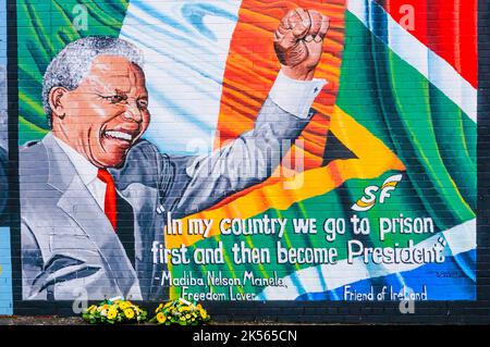 Belfast, Nordirland. 7. Dezember 2013 - links Floral Hommagen an Mandela Wandbild nach dem Tod von Nelson Mandela am 5. Dezember. Bildnachweis: Stephen Barnes/Alamy Live-Nachrichten Stockfoto