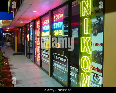 Vor einem Fotogeschäft mit Neonschildern für Canon und Nikon Stockfoto