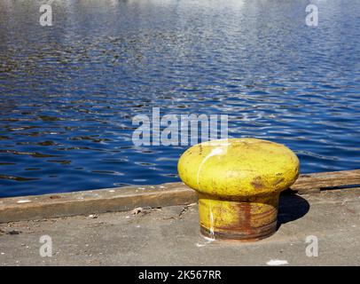 Gelb gestrichener Poller am Kai im Hafen von East Loch Tarbert, Argyll und Bute. Schottland Stockfoto