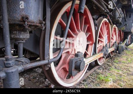 Antriebsmechanismus in einer historischen und beschädigten Dampflokomotive, die auf einem Seitenwagen steht. Stockfoto