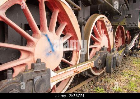 Antriebsmechanismus in einer historischen und beschädigten Dampflokomotive, die auf einem Seitenwagen steht. Stockfoto