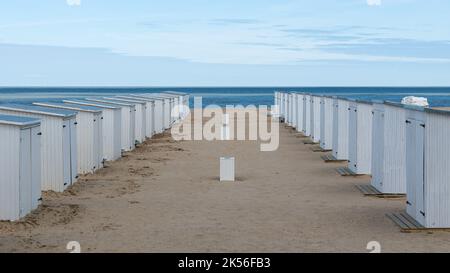 Knokke Heist, Flämische Region - Belgien - 04 03 2021 - Weiße Strandhütten in einer Reihe am Sandstrand in der Nebensaison Stockfoto