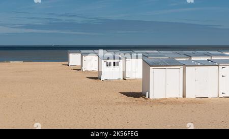 Knokke Heist, Flämische Region - Belgien - 04 03 2021 Weiße Strandhütten in einer Reihe am Sandstrand in der Nebensaison Stockfoto