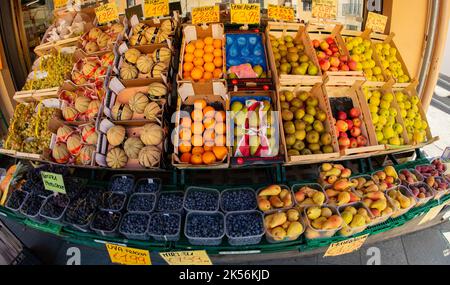 Fossano, Italien - 09. September 2022: Gemüsehändler mit bunten Früchten in Kisten in der Draufsicht, Fischauge Stockfoto